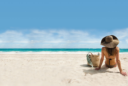 Frau sitzt am einsamen Strand