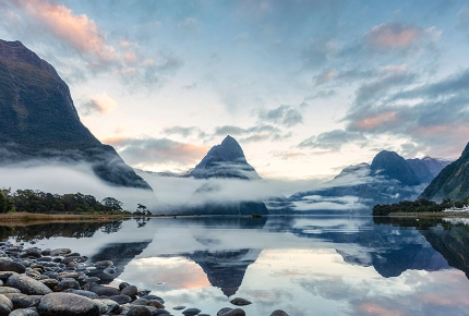 Blick über einen See auf die Berge am Milford Sound
